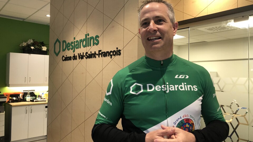 A man smiling and wearing sportswear with '' Desjardins '' written on it.  This is Joel Bernier, the organizer of the Grand Défi Desjardins. 