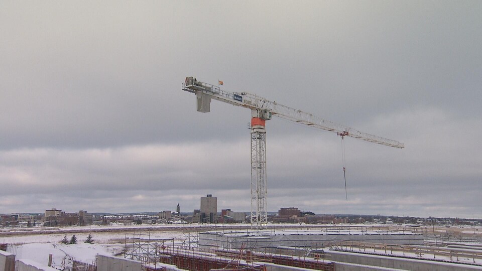 Un grue devant l'horizon d'un centre-ville.
