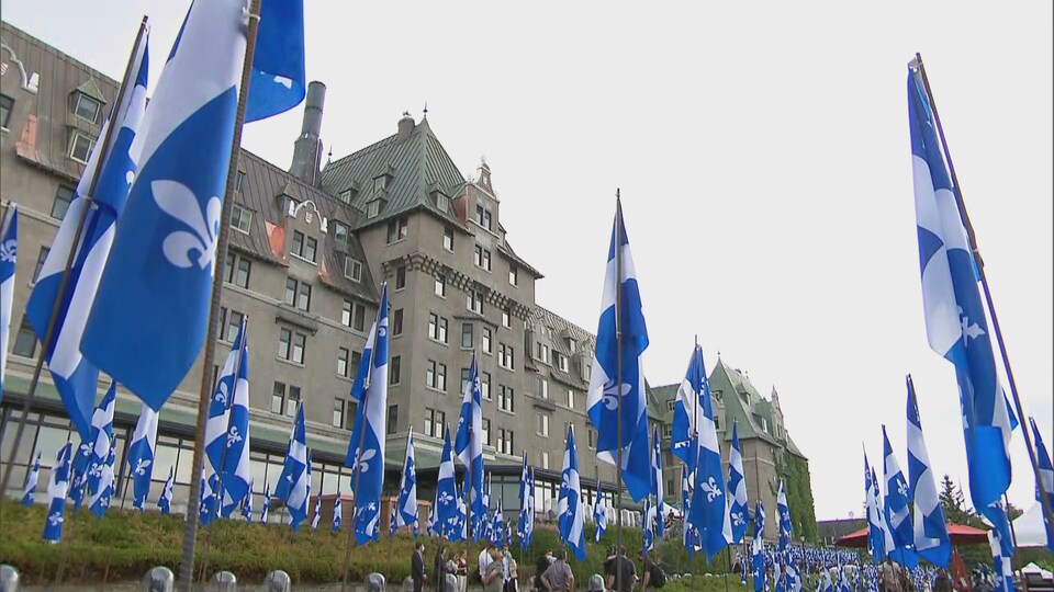 Vue en contre-plongée du Manoir Richelieu avec, à l'avant-plan, des drapeaux du Québec.