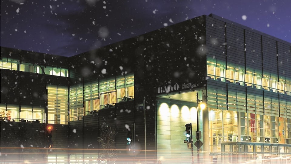 Photo de nuit de la Grande Bibliothèque à Montréal, sous la neige