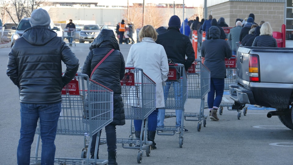 Des gens font la file dehors avec des paniers
