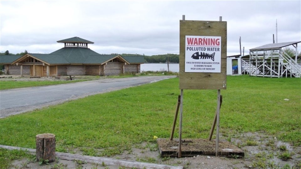 Un panneau d'avertissement indique que l'eau de la rivière est contaminée.