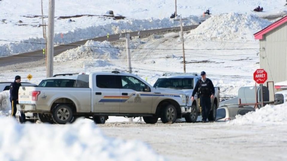 Des agents de la Gendarmerie royale du Canada devant des véhicules de police.