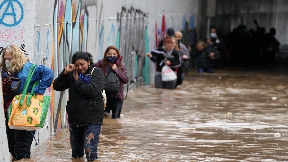 Des passagers évacuant une rue inondée.