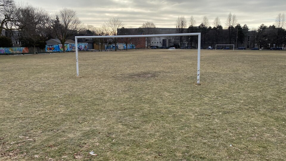 Les poteaux d'un but de soccer, sans filet, au centre d'un parc municipal.