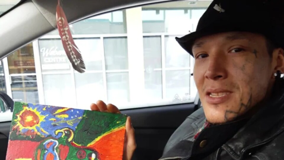 Une photo de Greg Ritchie dans une voiture montrant une toile.