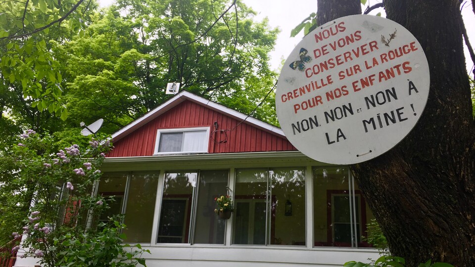 Une enseigne devant une maison sur laquelle on peut lire « Nous devons conserver Grenville-sur-la-Rouge pour nos enfants. Non, non et non à la mine! »