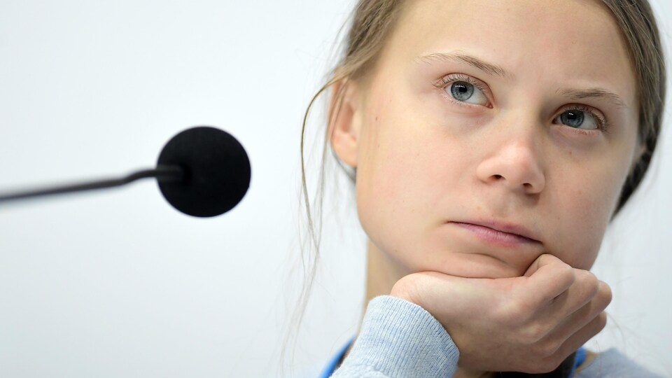 Plan rapproché de Greta Thunberg, qui affiche un air perplexe.