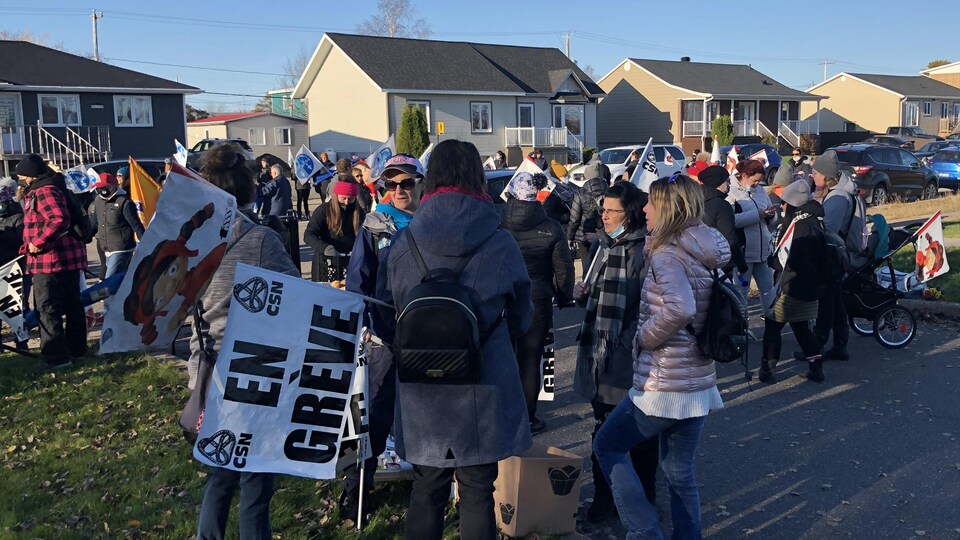 Plusieurs personnes tiennent des pancartes en grève.