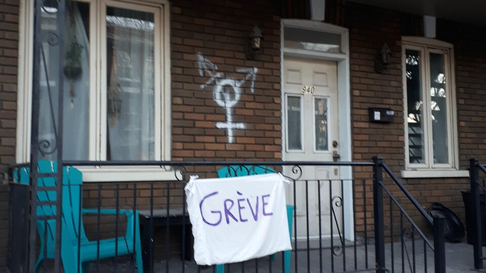 Un drap blanc sur un balcon sur lequel on peut lire ''grève''