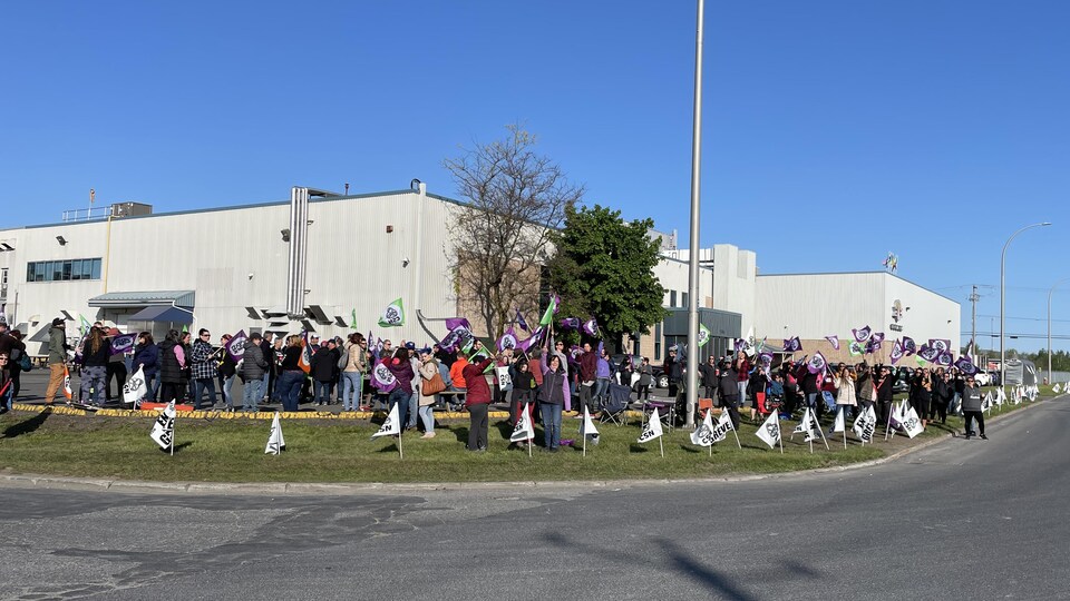 People protest in front of the factory.