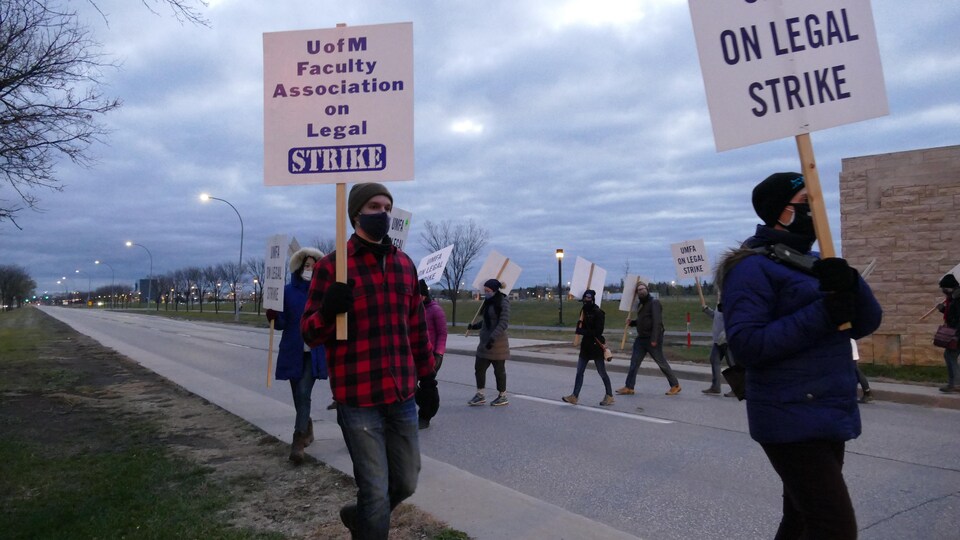 Des professeurs de l'Université du Manitoba dans la rue avec des pancartes lors d'une grève des professeurs.
