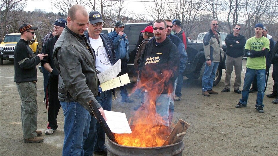 Des hommes près d'un feu dans un baril.