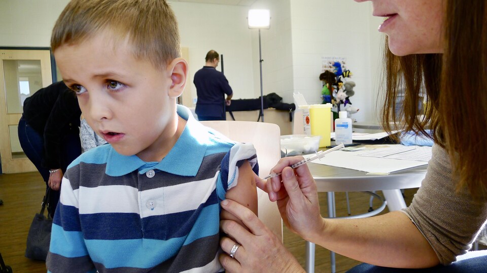 Un enfant se fait vacciner contre la grippe.