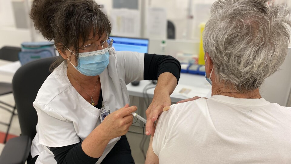Une infirmière inocule un vaccin à un patient. 