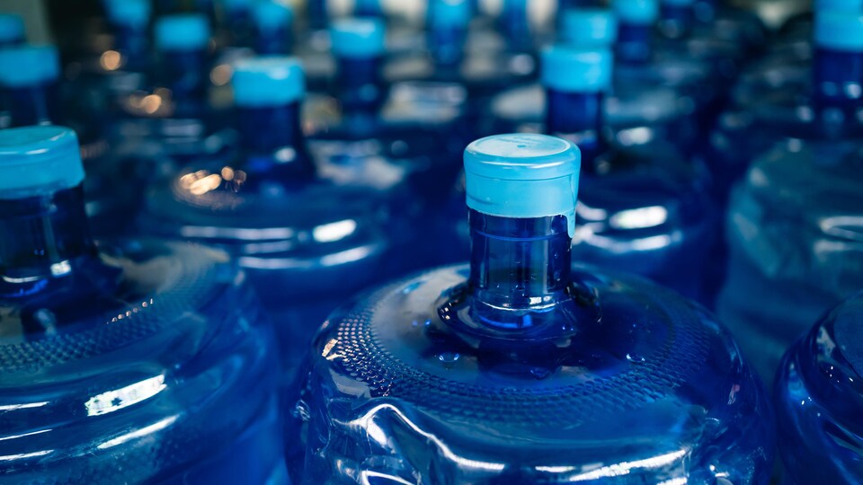 Plusieurs grosses bouteilles en plastique de 18 litres d'eau.