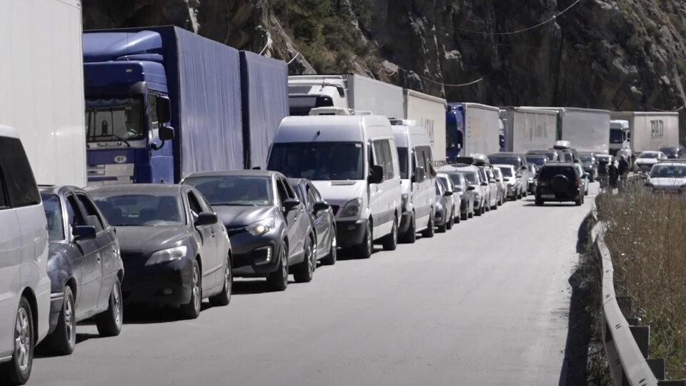 Une file de véhicules sur une route russe menant en Géorgie.