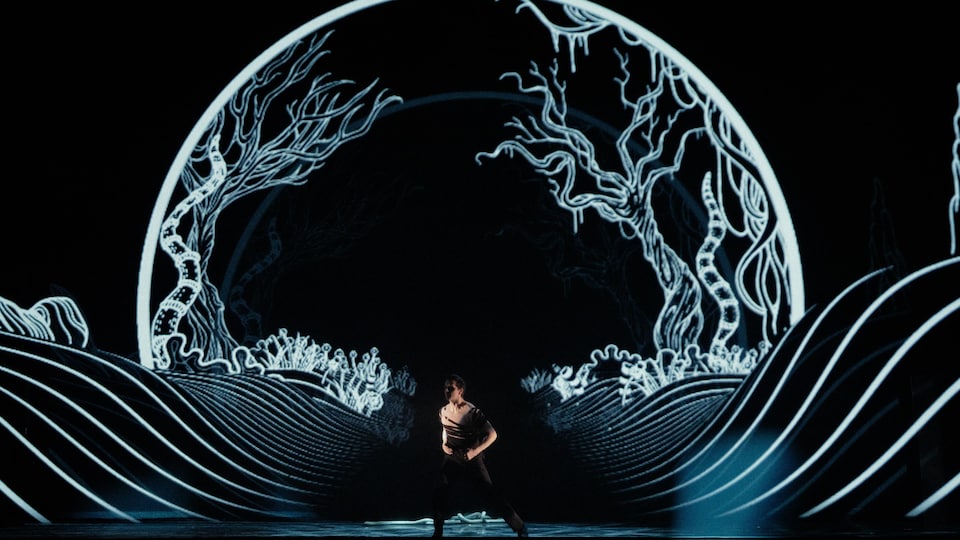 Un homme danse sur scène. 
