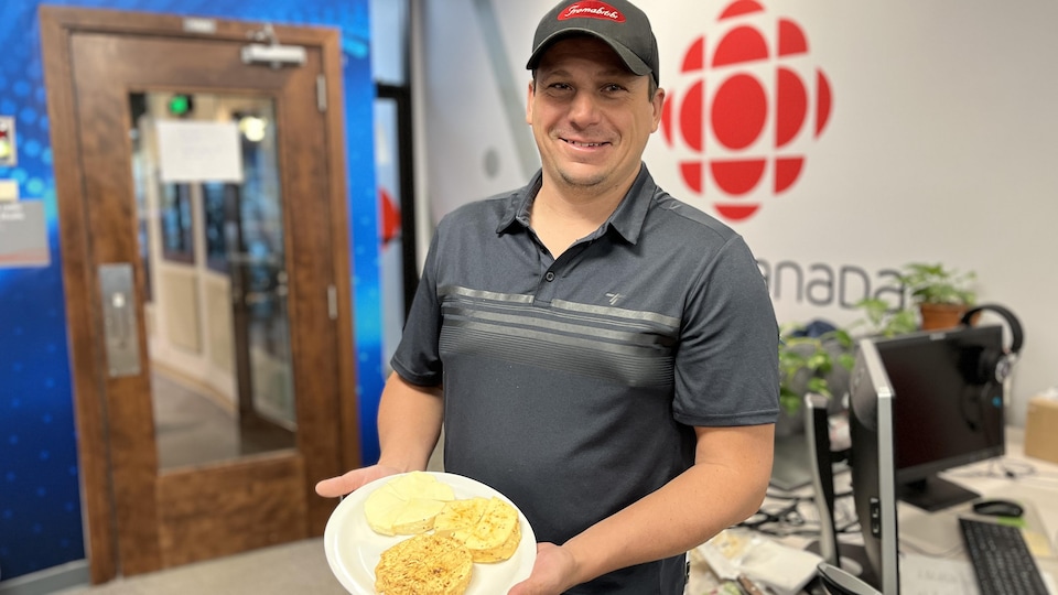 Guillaume Lemieux tient une assiette avec trois fromages dans les locaux de Radio-Canada à Rouyn-Noranda.