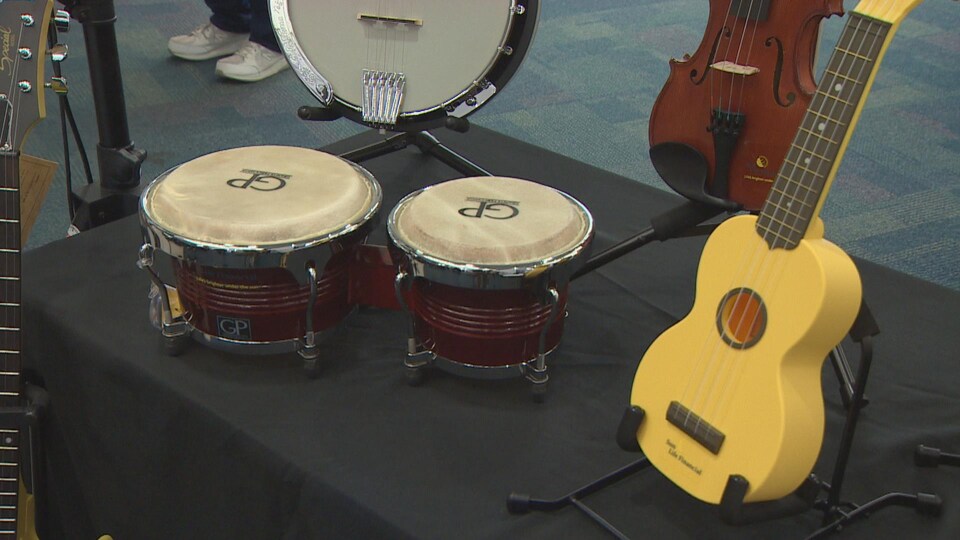 Instruments de musique exposés sur une table (des guitares et des tambours)