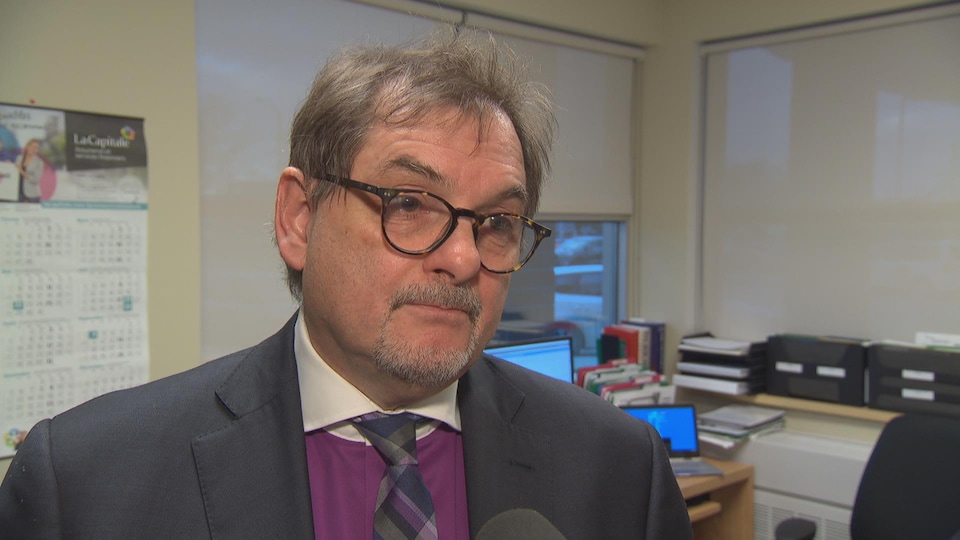 L'homme est interviewé dans son bureau