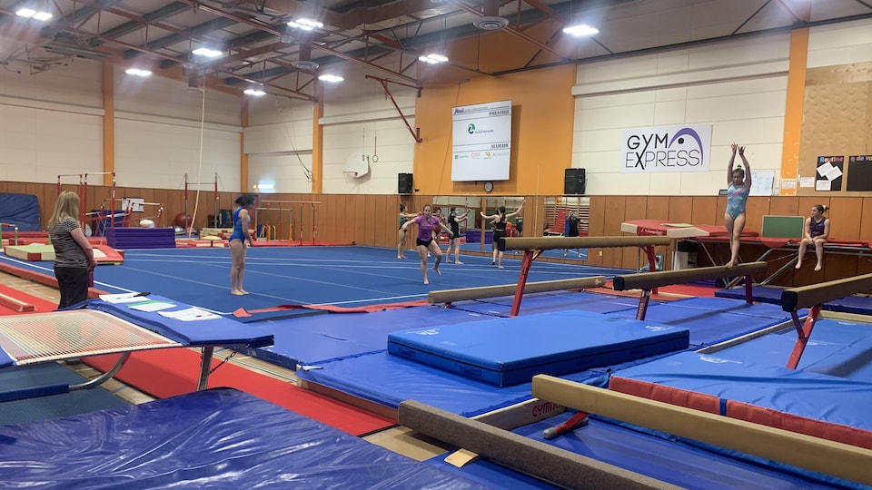 Des gymnastes s'entraînent sur un plateau de gymnastique.