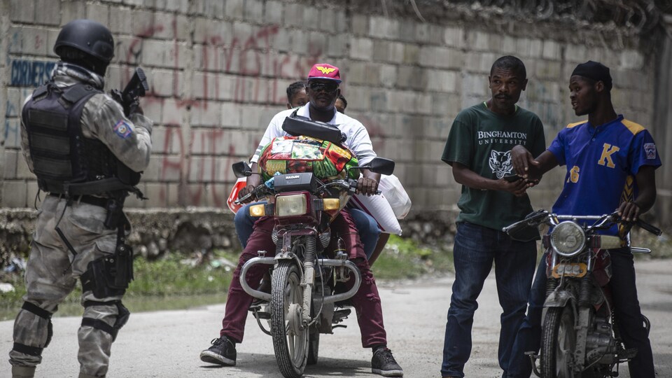 An armed policeman stood in front of the residents on motorcycles.