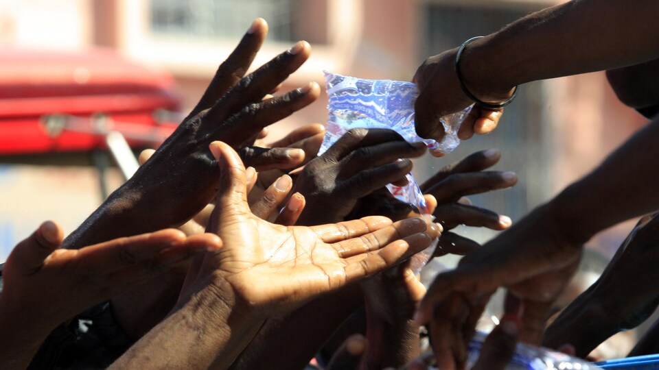 Distribution de sacs d'eau à Port-au-Prince, trois jours après le séisme du 12 janvier 2010