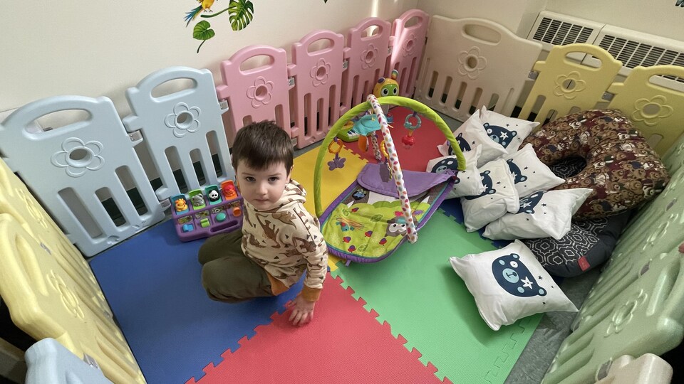 Un enfant entouré de jouets.