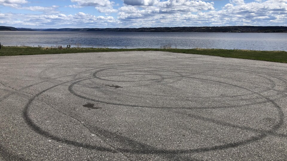 Des traces de pneus en rond sur l'asphalte.