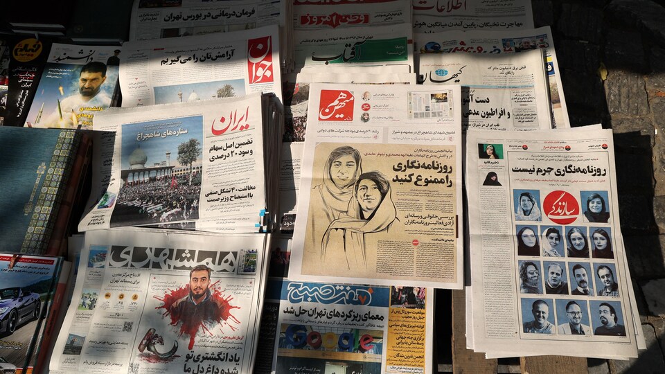 Journaux iraniens empilés dans un kiosque.