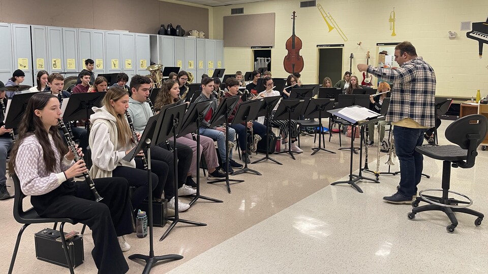Plusieurs élèves dans une salle de classe de musique en train de jouer des instruments.