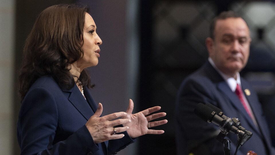 Au premier plan, Kamala Harris parle à la presse à côté d'Alejandro Giammattei, qui la regarde.