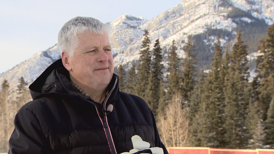 Harvey Locke dehors l'hiver pendant une entrevue à Banff. Les montagnes Rocheuses sont derrières lui.
