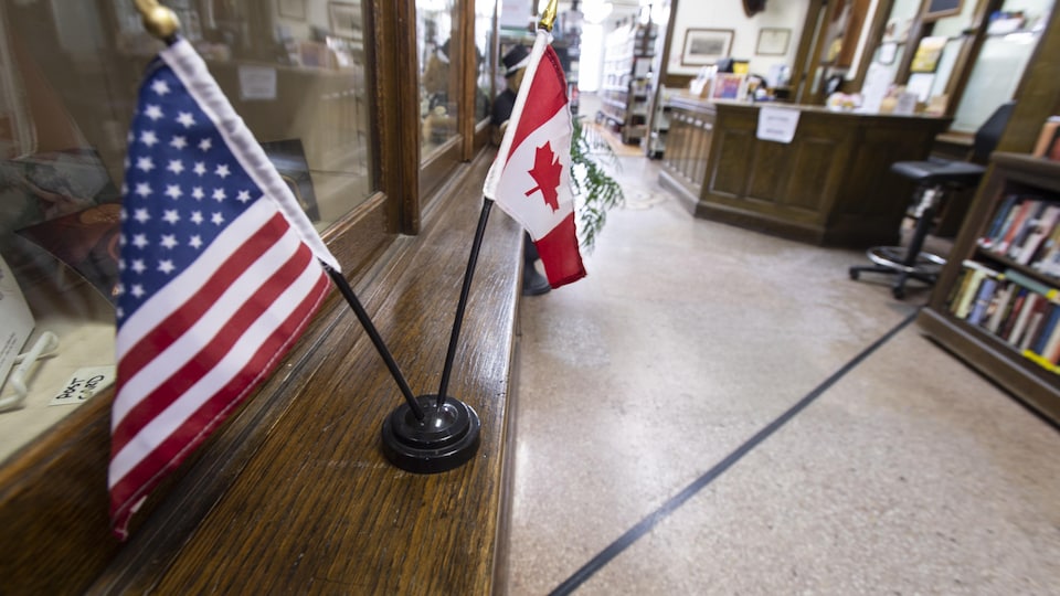 Une ligne marque la frontière entre le Canada et les États-Unis dans la bibliothèque et salle d'opéra Haskell. De petits drapeaux des deux pays sont disposés sur un bureau dans l'édifice.