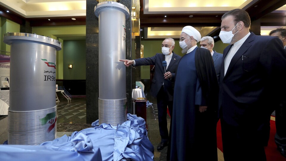 Des hommes debout lors d'une exposition des travaux menés par l'Iran en matière de nucléaire.