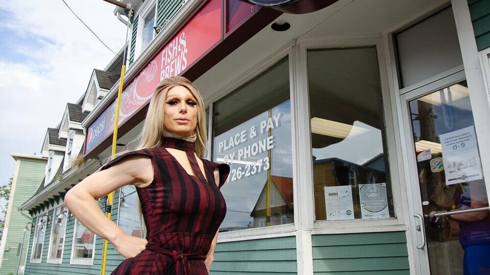 Une drag queen devant un restaurant.