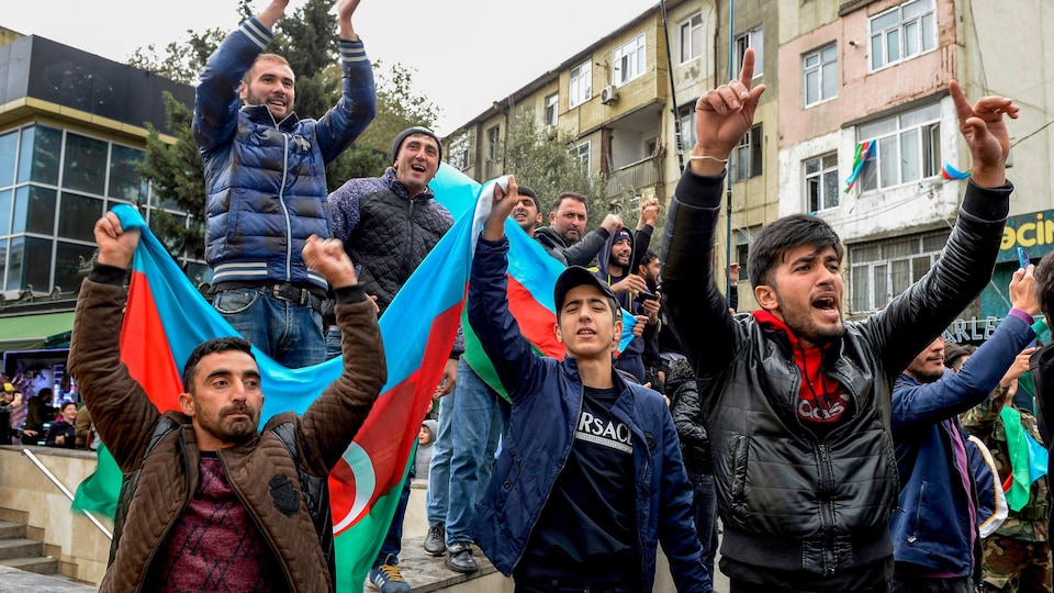 Des manifestants en portent le drapeau azéri.