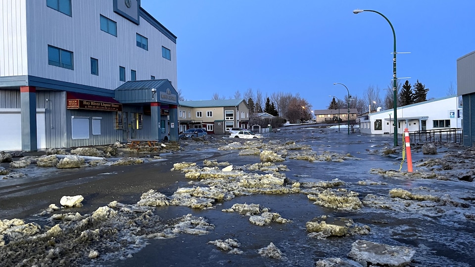 De la glace et de l'eau envahissent une rue de Hay River, aux Territoires du Nord-Ouest, le 12 mai 2022.
