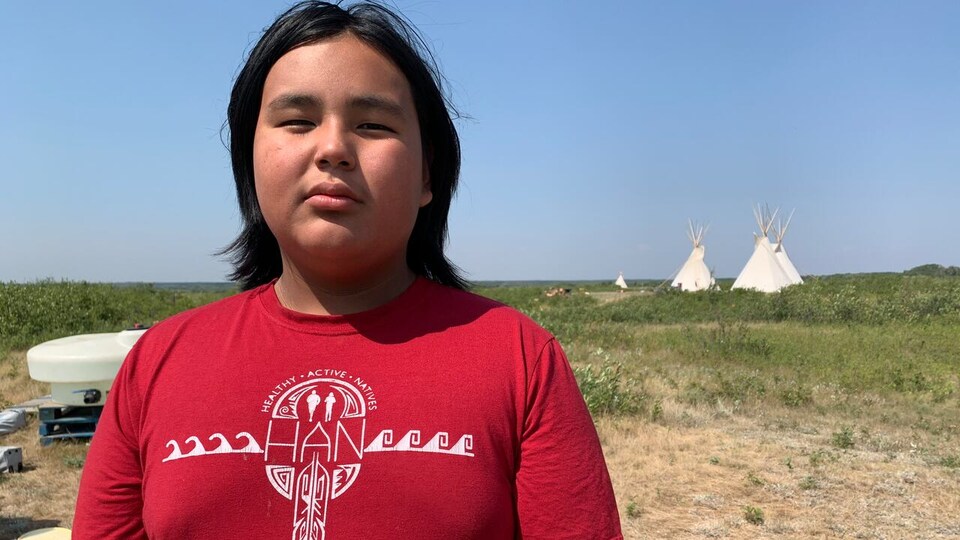 Hayden Blackbird avec des tipis derrière.