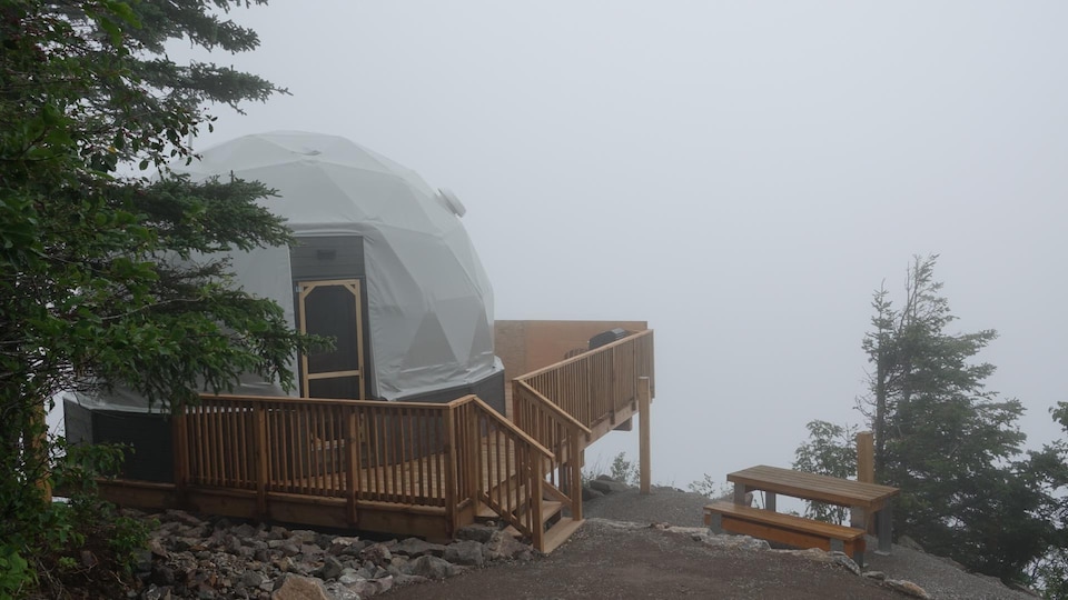 Un géodôme dans un décor de brouillard.