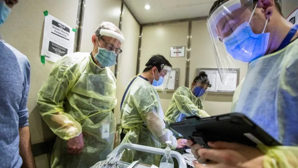 Des médecins masqués avec une blouse dans un hôpital.
