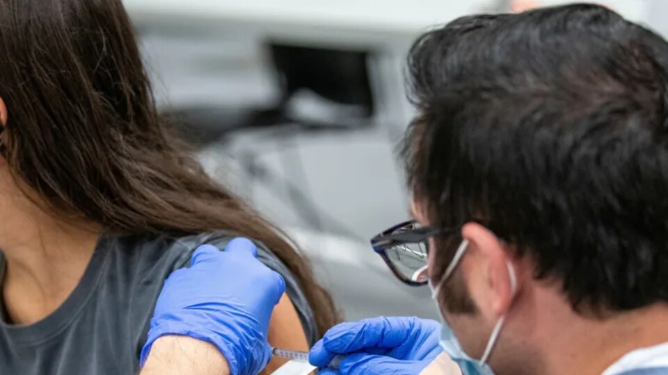 Une jeune fille reçoit une dose de vaccin.