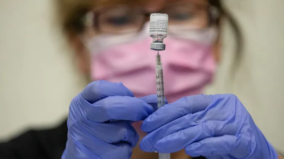 Une infirmière injecte une dose de vaccin.