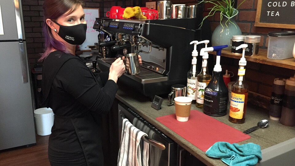 Une femme fait du café.