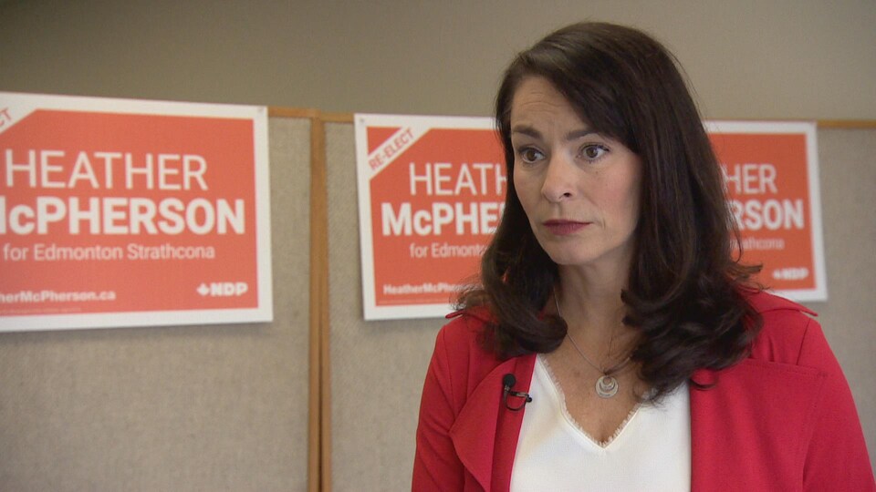 Heather McPherson devant ses affiches de campagne.