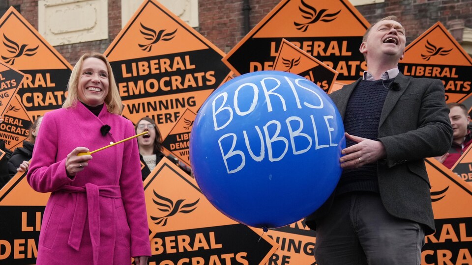 Helen Morgan s'apprête à crever un ballon sur lequel est écrit : « Boris Bubble ».