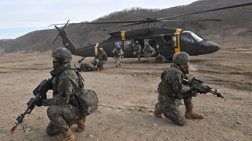 Des soldats descendent d'un hélicoptère UH-60 Black Hawk de l'armée américaine.