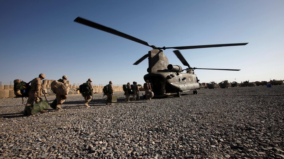Des militaires canadiens s'apprêtent à quitter la base de Zangabad, en Afghanistan, à bord d'un hélicoptère de l'armée canadienne, le 18 juin 2011. 