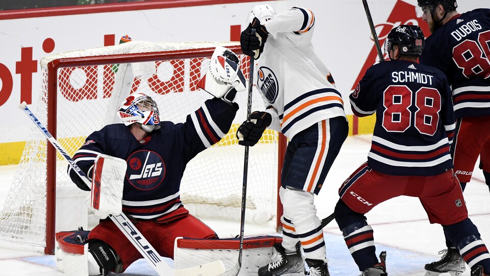 Connor Hellebuyck arrête un tir.